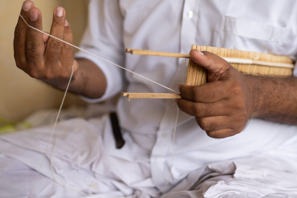 The weaver is weaving th silk thread